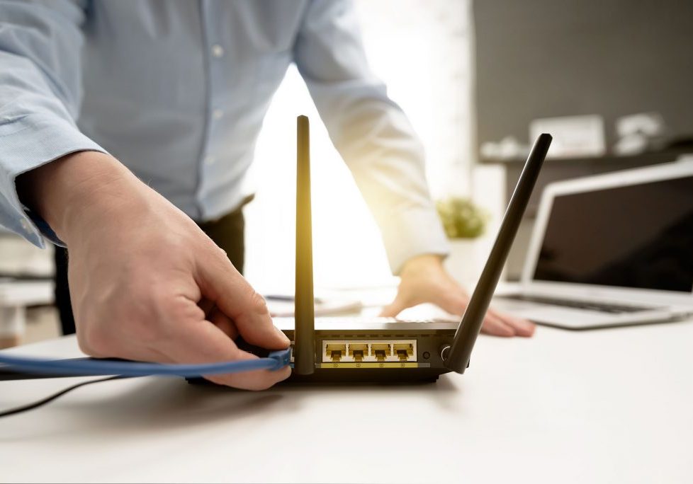 Man connects the internet cable to the router's socket